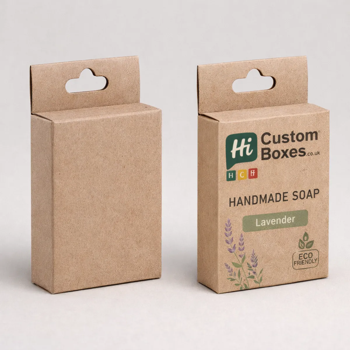 Two upright brown kraft soap boxes with hanging tabs, featuring a minimalist lavender design and eco-friendly logo. class=